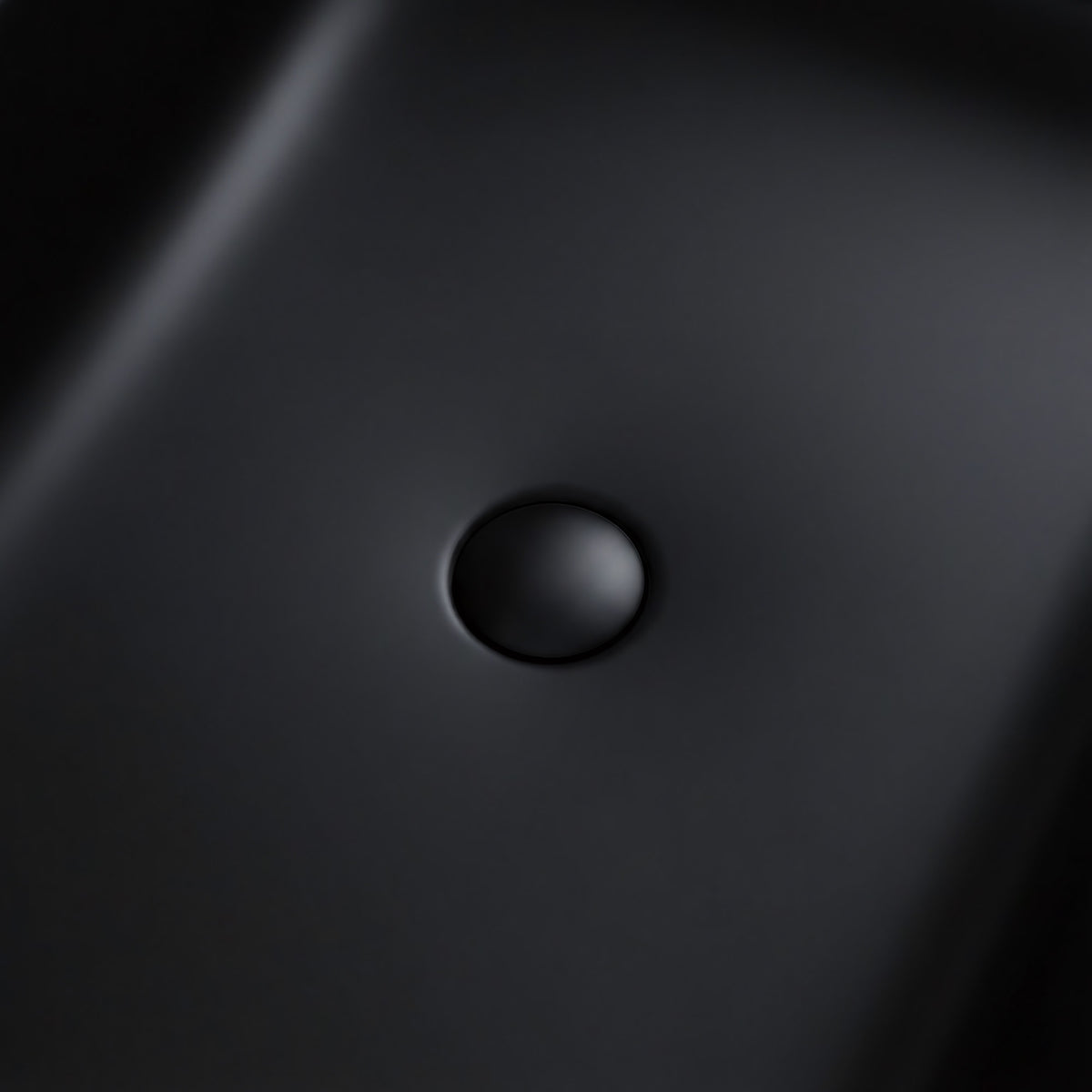 OBSIDIAN freestanding solid surface soaking bathtub with matte black finish and integrated overflow detail