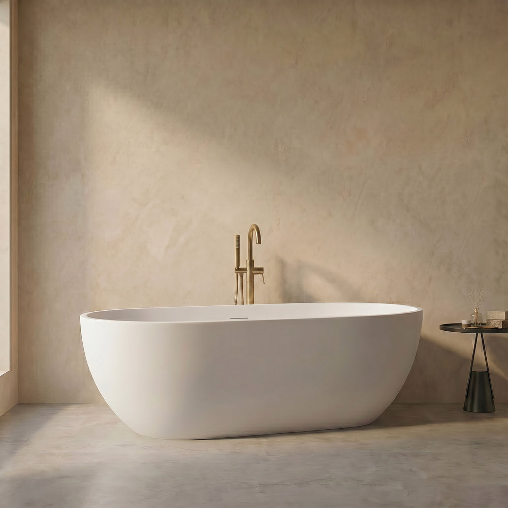 OBSIDIAN freestanding solid surface soaking tub in white oval shape with brushed gold floor-mounted faucet